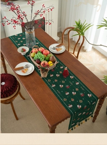Detailed Christmas table runner with Santa Claus motifs and decorative tassels