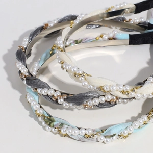 Close-up of three pearl floral hairbands with metal chains and rhinestone details