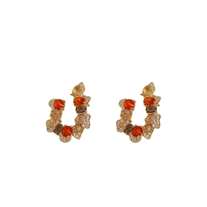 Luxury vintage U-shaped gold earrings with colorful zircon stones on a white background