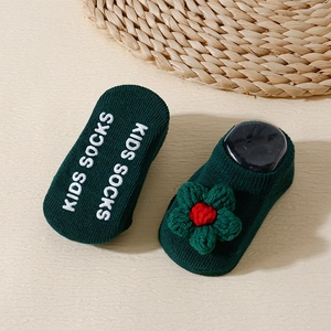 Close-up of baby floor socks with floral knit detail and non-slip rubber grips on sole