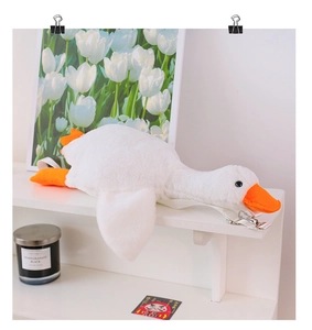 Detailed macro view of plush white goose bag showing soft texture and orange beak detail