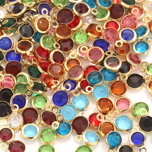 Close-up of colorful 6mm crystal birthstone charms with golden metal frames and top rings