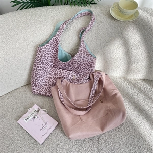 Detail of leopard print tote bags on a cozy white sofa with home decor accessories