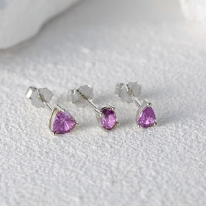 Macro shot of S925 silver earring set with heart and teardrop purple gems