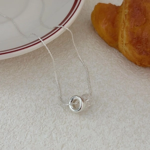 Minimalist 925 sterling silver circle necklace with clear bead on cream background
