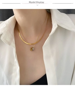 Close-up of a double-layered gold snake chain necklace with interlaced tricolor rings