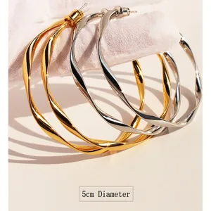 Golden and silver 5cm twisted hoop earrings with elegant wave texture and metallic finish