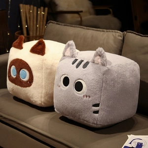 Macro detail of cube-shaped plush cat pillows with soft faux fur texture on grey sofa