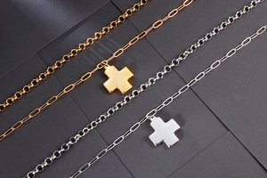 Detail shot of gold and silver double-layered necklaces with polished cross pendants