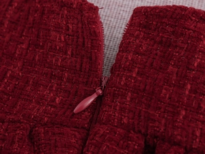 Vue détaillée de la texture du tissu en tweed rouge et de la fermeture éclair invisible