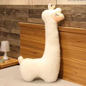 Detail of white alpaca plush pillow featuring soft fleece fabric and cute embroidered face