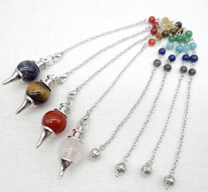 Detail of four natural stone pendulums with chakra beads and ornate silver chains