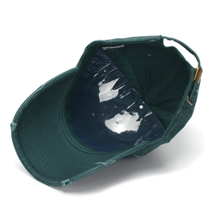 Dettaglio del cappellino verde scuro effetto invecchiato con fibbia in metallo e bordi