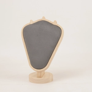 Close-up of luxury velvet necklace display stand with premium light wood frame