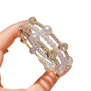 Luxuriöses mehrlagiges Perlenarmband mit funkelnden Diamanten und Goldlegierung