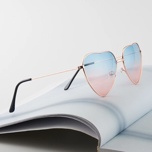 Retro heart-shaped sunglasses with rose gold metal frames and blue-pink gradient lenses