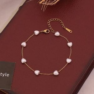 Primer plano de un collar de acero inoxidable dorado con perlas de imitación de corazón