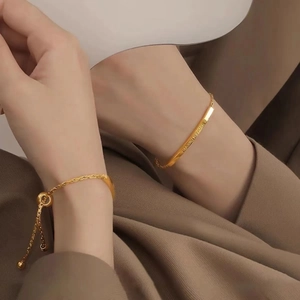 Detailed shot of an adjustable gold minimalist bracelet with HAVE A DREAM engraving