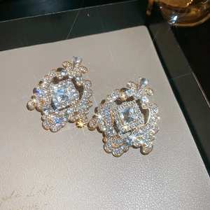 Gros plan de boucles d'oreilles baroques dorées avec cristaux sur un plateau