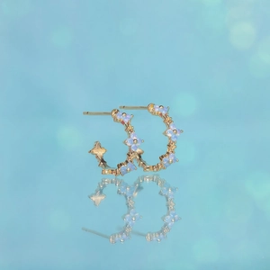 Elegant 18K gold-plated C-shaped hoop earrings with blue zircon flower accents