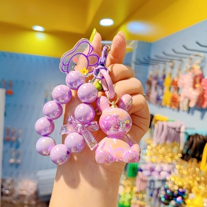 Detail showing a purple rabbit charm with beaded wrist strap and translucent bow accessory