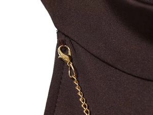 Detailed macro view of the golden metal chain and lobster clasp on the brown dress fabric