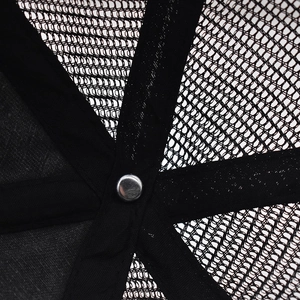 Macro detail of breathable black mesh material and inner stitching on the baseball cap