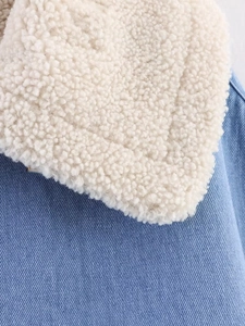 Detail of blue denim fabric with white faux shearling lining on jacket collar