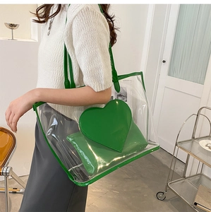 Detailed shot of transparent PVC tote bag with green trim and matching heart pouch