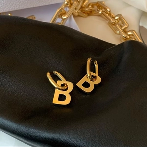 Chic golden B-letter earrings on black leather with elegant gold chain accessories