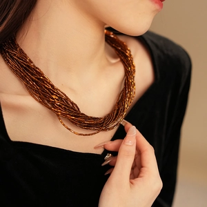 Dettaglio della collana di perle di bronzo a più strati sul collo con chiusura magnetica