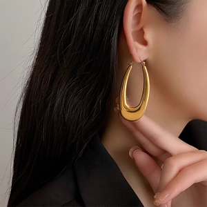 Minimalist gold U-shaped hollow chunky hoop earrings shown on model for stylish look