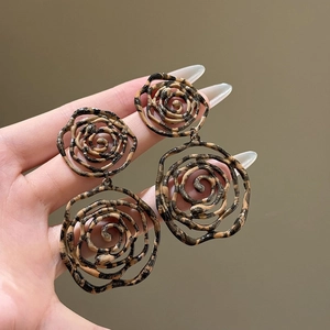 Gros plan sur des boucles d'oreilles vintage doubles roses évidées avec motif léopard