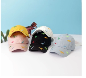 Detail of colorful dinosaur embroidery on multiple colored cotton baseball caps for kids
