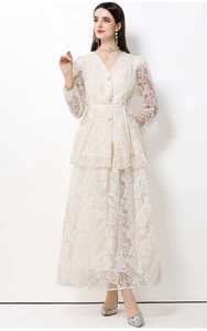 Detailaufnahme von weißem Spitzenkleid mit floralen Mustern und feinen Knöpfen