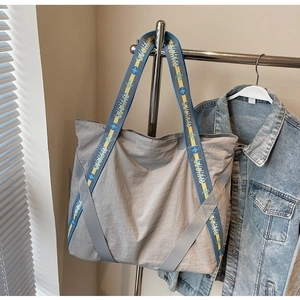 Détail d'un sac cabas gris avec une bandoulière tissée GUCHAO en bleu et jaune