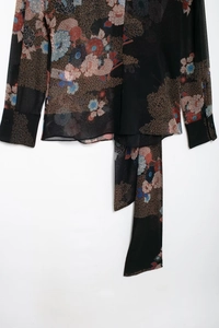 Close-up of floral print chiffon blouse featuring vintage patterns and button cuffs