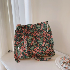 Detailed view of quilted cotton fabric with green and pink floral patterns and strap