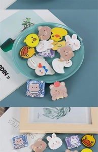 Detail of cute acrylic animal pins featuring yellow ducks, brown bears, and white rabbits