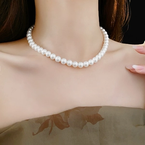 Gros plan d'un collier de perles blanches élégantes sur le cou d'un mannequin