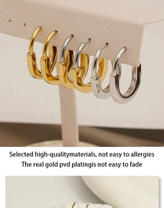 Close-up of gold and silver U-shaped stainless steel geometric hoop earrings on display