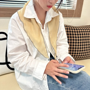 Close-up of a woman wearing a yellow triangle sheer scarf as a stylish shawl accessory