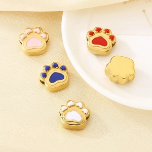 Detailed macro of golden animal paw charms with colorful enamel filling for DIY jewelry