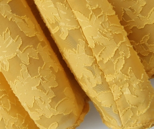 Detaillierte Makroansicht von gelbem Jacquard-Stoff mit eleganter Blumenstickerei