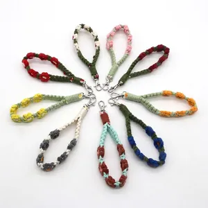 Nine colorful handmade crochet flower wristlet keychains with silver metal clasps on white background