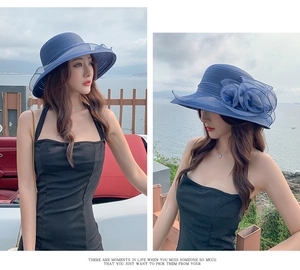 Detail of blue wide-brim organza sun hat with delicate floral accent for beach vacations