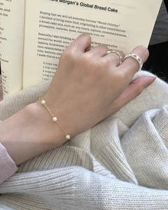Detail of s925 silver beaded bracelet and luxury rings on a model with lifestyle aesthetic