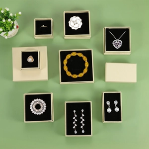 Variety of elegant jewelry in beige gift boxes including rings, earrings and necklaces