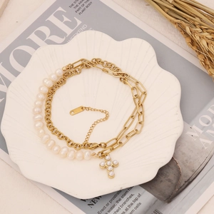 Detail of gold-plated stainless steel chain with natural pearls and cross pendant