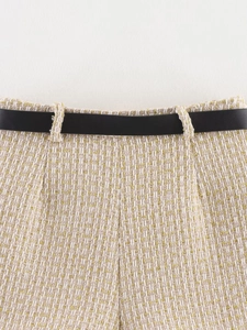 Detailed macro view of beige tweed fabric with gold threads and a black belt accessory